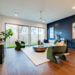 A welcoming living area with a blue accent wall, hardwood floors, and sliding glass doors leading to a backyard.