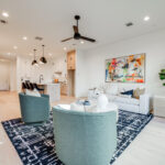 A sleek, modern living area with recessed lighting, comfortable seating, and artwork on the walls.