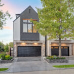 A lovely two story home from Mazzarino, with a gray exterior, large windows on the second story, and a garage